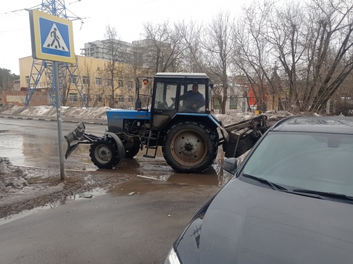 Трактор убирает огромную лужу на..