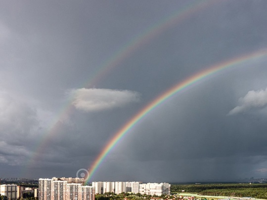 Виды города на фоне радуги..